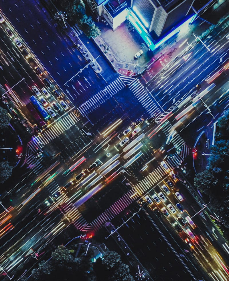 Vista aérea de una concurrida intersección urbana con semáforos y coches.